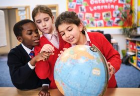 Fairfield pupils in Geography looking at a globe